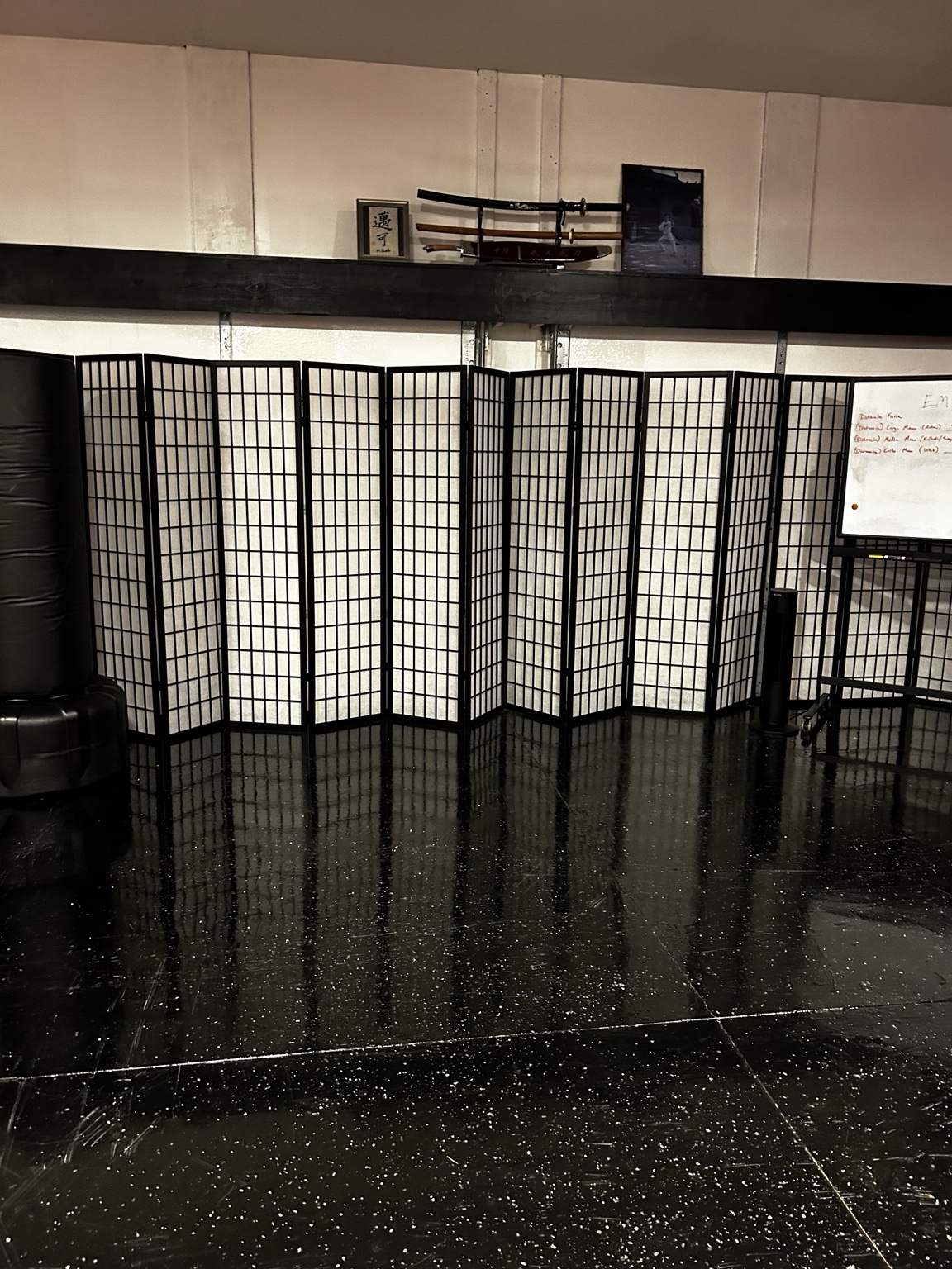 MUSUBI dojo training floor with shoji screens and weapons display